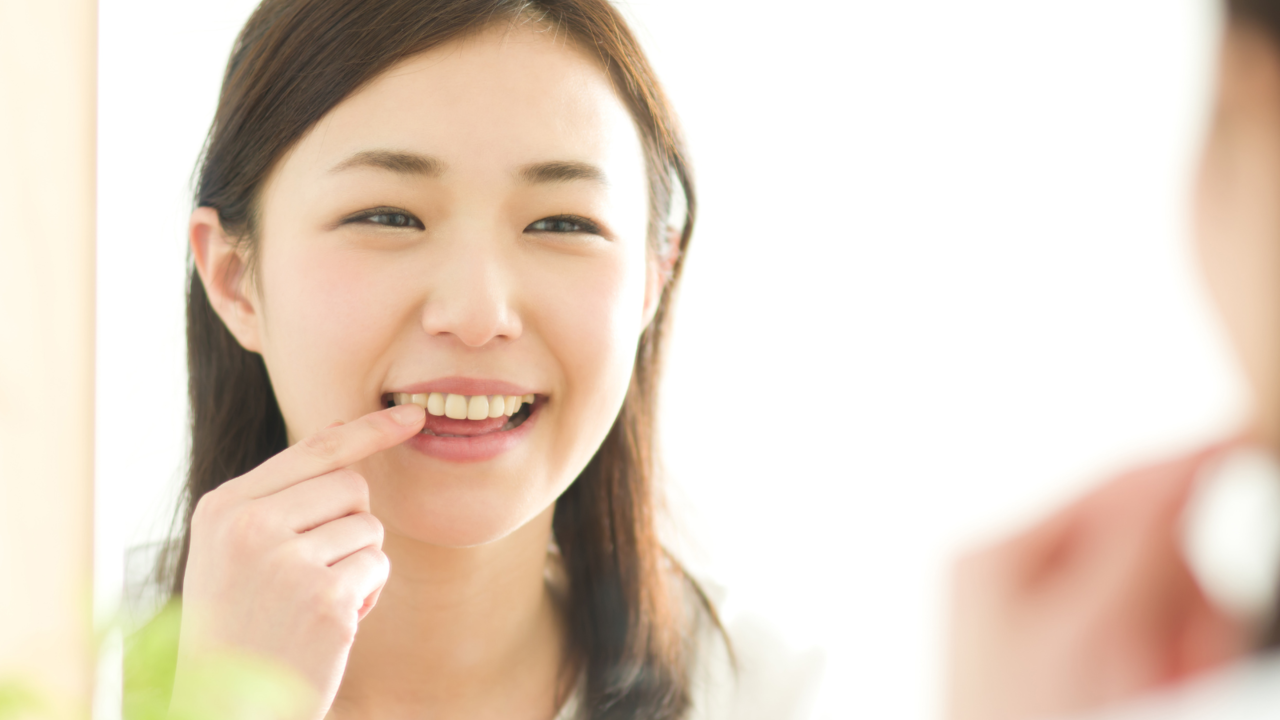 歯並びを確認する笑顔の女性