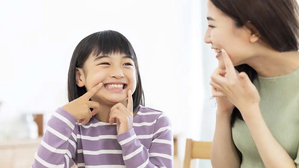歯を見せて笑う親子