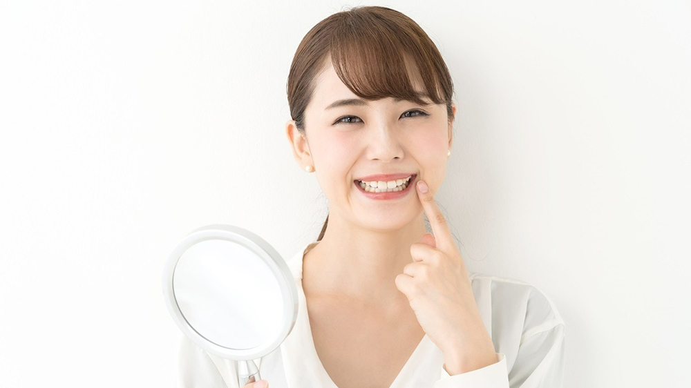 歯並びを確認する笑顔の女性